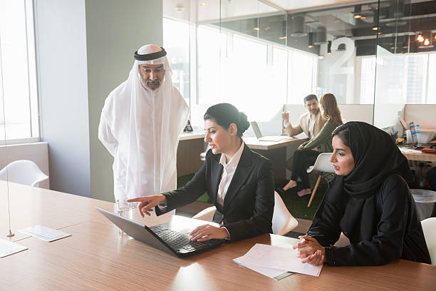 Business professionals discuss strategy in a modern office, highlighting benefits of RAKEZ Free Zone operations.