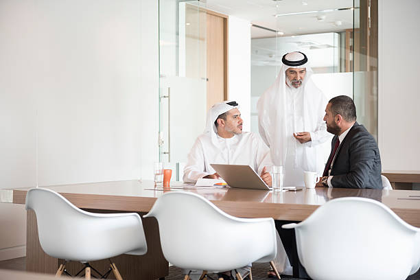 Business professionals discussing investment opportunities at RAKEZ Free Zone in a modern conference room.